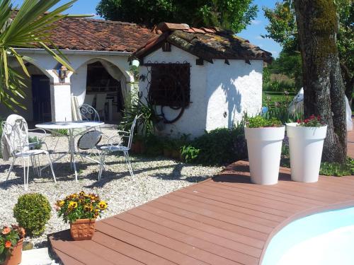 a backyard with a wooden deck and a small house at Le Clos de Saint Amour in Montauban