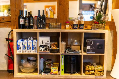a shelf with wine bottles and other items on it at Sahlihuus Unterkunft in Köniz