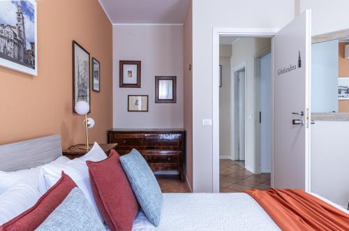 a bedroom with a bed with red and blue pillows at Room & Breakfast Canalino 21 in Modena