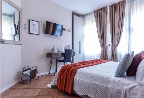 a bedroom with a bed and a desk and a television at Room & Breakfast Canalino 21 in Modena