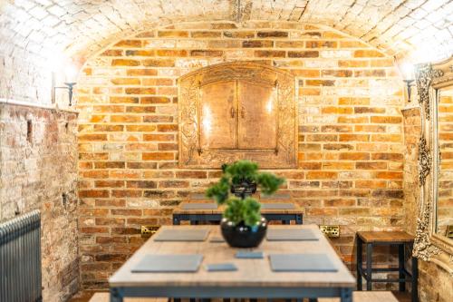 a brick room with a table with a plant on it at St Marys Quarters in Nottingham