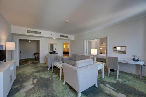 a living room with a couch and a table at Millennium Lakeview Hotel in Dubai