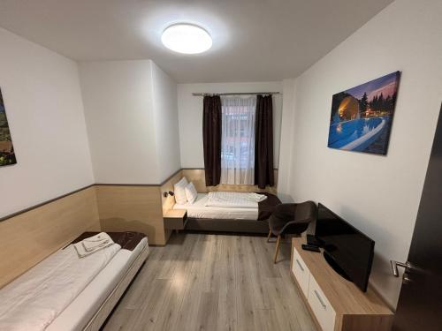 mały pokój z 2 łóżkami i oknem w obiekcie Pizza Tábor Apartman w Miszkolcu