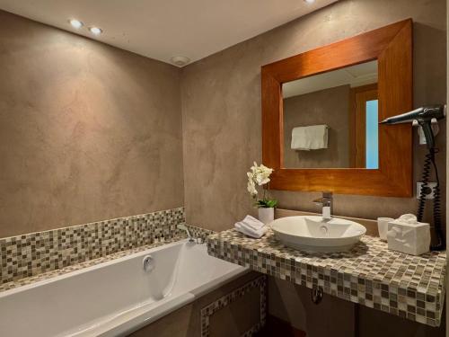 a bathroom with a sink and a tub and a mirror at Cannes Villa St Barth in Cannes