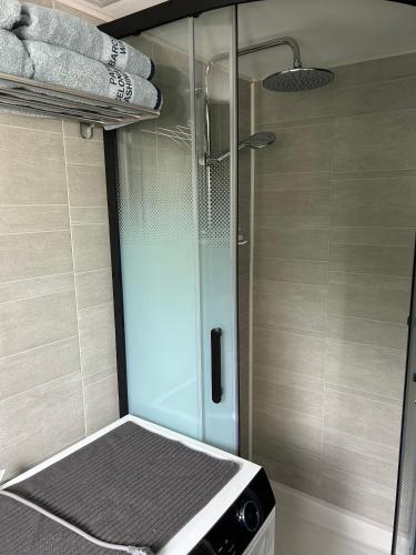 une douche avec une porte vitrée dans une salle de bain dans l'établissement T2 Mouguerre aux portes de Bayonne et Biarritz, à Mouguerre