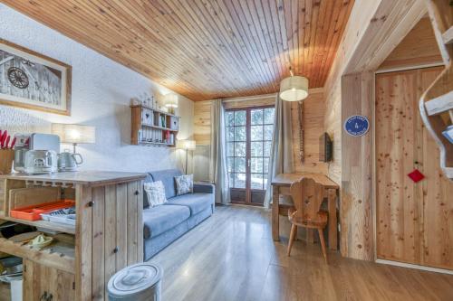 a living room with a blue couch and a table at Gawal 1 in Villard-Reculas