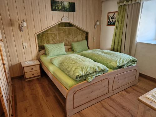 a bedroom with a large bed with green pillows at Badhaus in Achenkirch