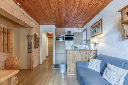 a living room with a blue couch and a kitchen at Gawal 1 in Villard-Reculas