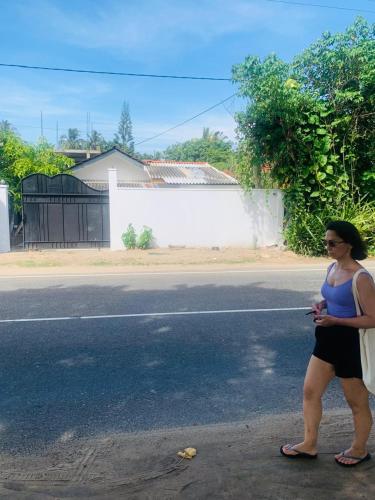 a woman standing on the side of a street at Pure Surf Villa in Weligama