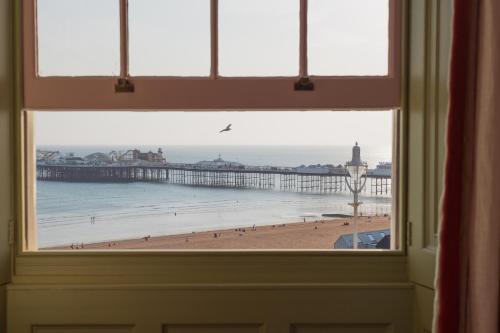 a window view of a beach with a pier at Drakes Hotel in Brighton & Hove