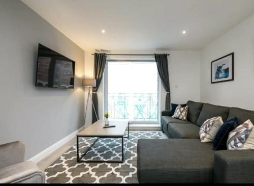a living room with a couch and a table at Fabulous Quayside Apartment with Free Parking in Liverpool
