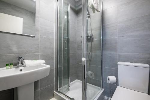 Un baño con ducha, inodoro y lavabo. en Fabulous Quayside Apartment with Free Parking, en Liverpool