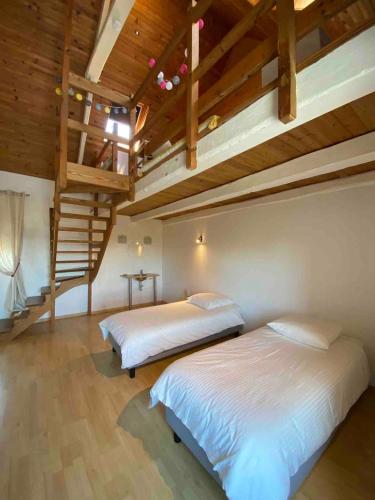 - 2 lits dans une chambre dotée de plafonds en bois dans l'établissement Aux Dix 'Jamet, à Tourville-sur-Sienne