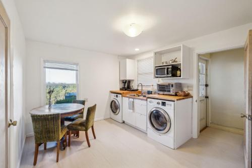 a kitchen with a table and a washer and dryer at Charming 1933 Ridge-Top Home with Stunning Views home in Oakland