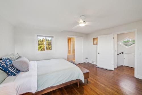 a white bedroom with a bed and a ceiling fan at Charming 1933 Ridge-Top Home with Stunning Views home in Oakland