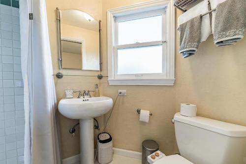 a bathroom with a sink and a toilet and a window at Charming 1933 Ridge-Top Home with Stunning Views home in Oakland