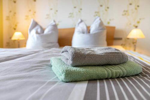 a pile of towels on a bed with pillows at Haus Dreeßen in Buchholz