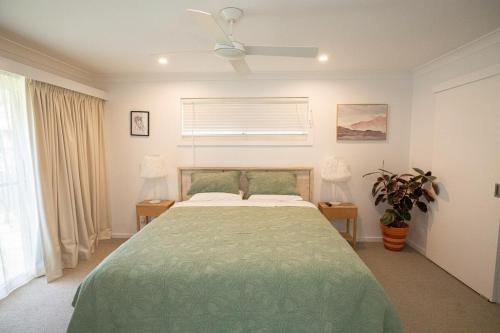 une chambre avec un lit avec une couette verte dans l'établissement Harper House, à Suffolk Park