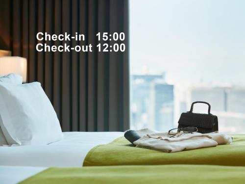 東京にあるMitsui Garden Hotel Ginza Premierのベッドの上でチェックイン/チェックアウトを記載したサイン