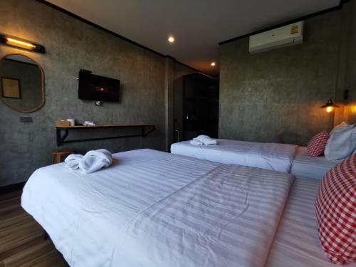 a hotel room with two beds and a tv at Lanta Chaolay in Ko Lanta