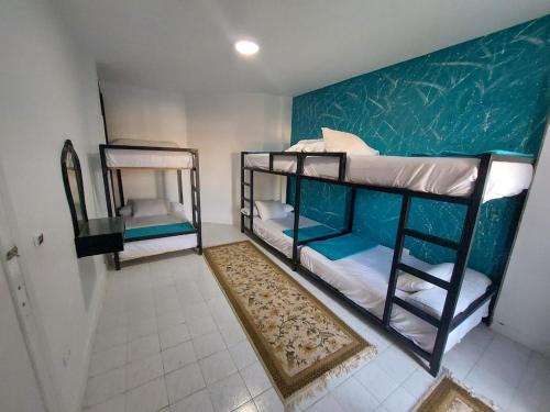 two bunk beds in a room with a green wall at Villa alkayan2 in fayed in ‘Ezbet el-Ibrâshi