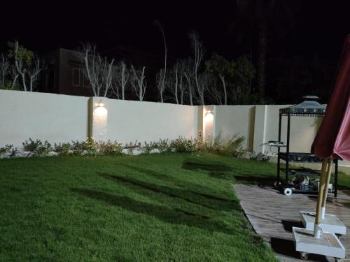 a backyard at night with a white fence at Villa alkayan2 in fayed in ‘Ezbet el-Ibrâshi