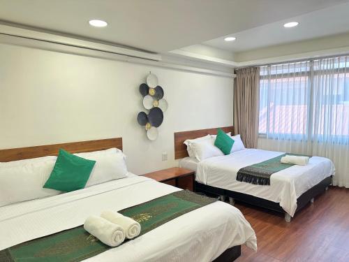 a hotel room with two beds and a window at Longzhu Guesthouse in Bangkok