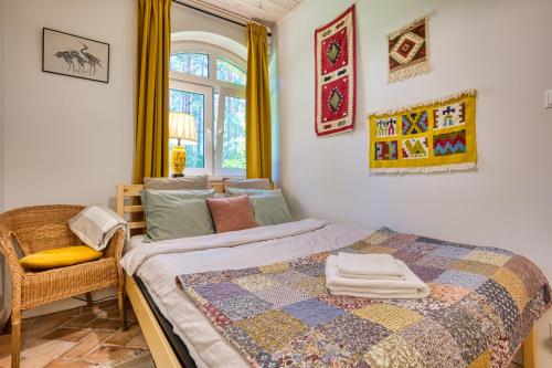 a bedroom with a bed and a chair and a window at UTASIÓWKA Mazury in Pasym