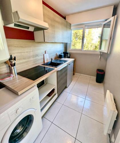 une cuisine avec une machine à laver et un évier dans l'établissement Charmant studio à Montbéliard, à Montbéliard