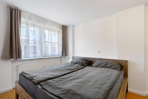 a bed in a room with a large window at Ferienwohnung Merlin in Ettenheim