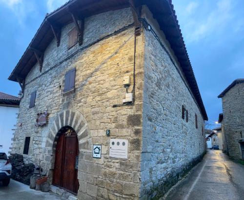 an old stone building with a red door at Casa Rural Ardantzena in Ardaiz