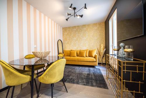 un salon avec un canapé jaune et une table dans l'établissement CIA - Triplex in Paris 17th, à Paris