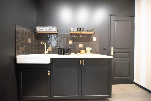 La salle de bains est pourvue d'un lavabo et d'un mur noir. dans l'établissement CIA - Triplex in Paris 17th, à Paris