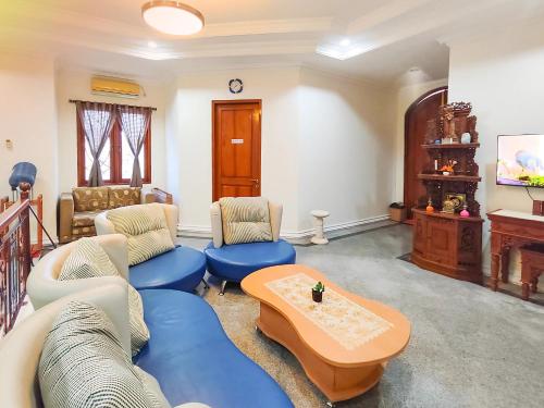 a living room with blue couches and a table at Palma Villa Homestay Klaten in Kuwoso