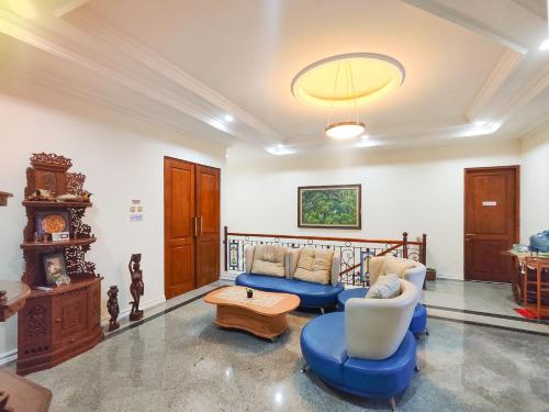 a living room with two blue couches and a table at Palma Villa Homestay Klaten in Kuwoso