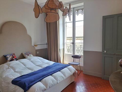 une chambre avec un lit avec une couverture bleue et une fenêtre dans l'établissement Superbe appartement cœur Avignon 6 personnes, à Avignon