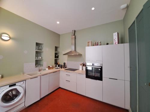 une cuisine avec des armoires blanches et une laveuse et une sécheuse dans l'établissement Superbe appartement cœur Avignon 6 personnes, à Avignon