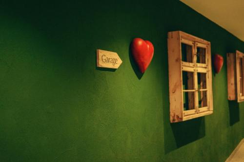 a green wall with hearts and a window at Mäsers Allgäuherz in Wiggensbach