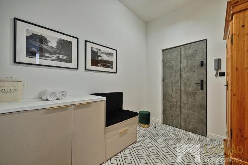 a room with a desk with a chair and a door at Kolorova Apart by LookAp - darmowy parking w centrum Łodzi! in Łódź