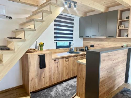 a kitchen with wooden cabinets and a staircase at Villa Pine in Lukavac