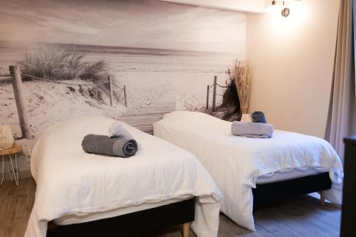 - 2 lits dans une chambre avec une fresque murale représentant la plage dans l'établissement charmante maison coeur de ville 6 personnes, à Les Sables-dʼOlonne