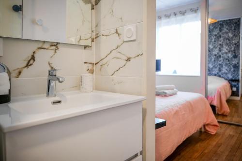 une salle de bain avec un lavabo et une chambre avec un lit dans l'établissement charmante maison coeur de ville 6 personnes, à Les Sables-dʼOlonne