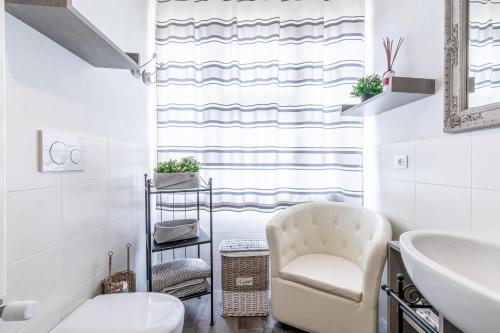 a white bathroom with a chair and a sink at Room & Breakfast Canalino 21 in Modena