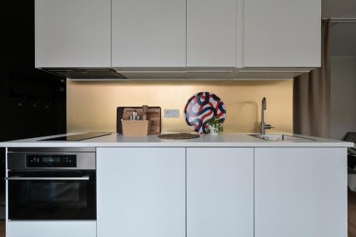 a kitchen with white cabinets and a doughnut on the counter at EttSmart Hotell in Sollentuna