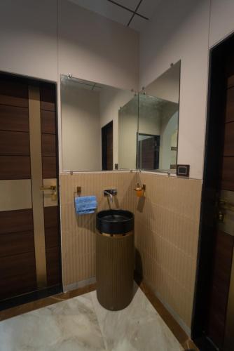 a bathroom with a large mirror and a trash can at Royal Cabana Lonavla - 6BHK Luxury Villa with Heated pool and Turf in Lonavala
