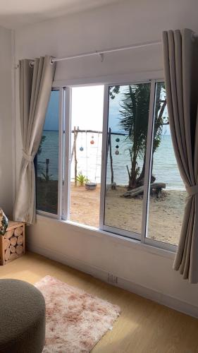 a room with a window with a view of the beach at Baan Konhualam Koh Libong in Ko Libong Island