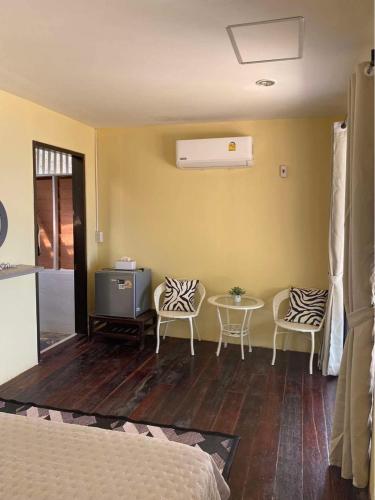 a room with a bed and two chairs and a table at Baan Konhualam Koh Libong in Ko Libong Island