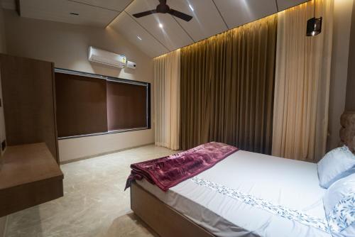 a bedroom with a large bed and a large projection screen at Royal Cabana Lonavla - 6BHK Luxury Villa with Heated pool and Turf in Lonavala