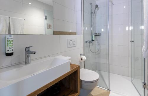 a white bathroom with a shower and a toilet at Hotel MeiSTAY - Self-Check-in in Meisterschwanden