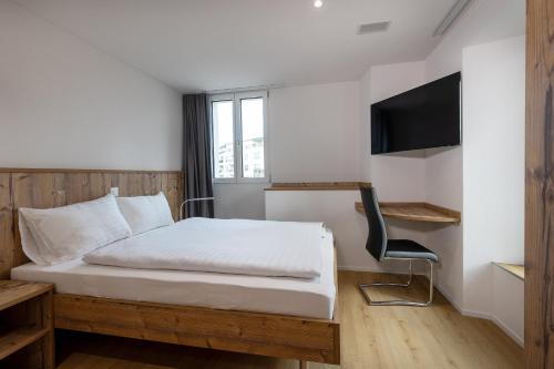 a hotel room with a bed and a tv at Hotel MeiSTAY - Self-Check-in in Meisterschwanden